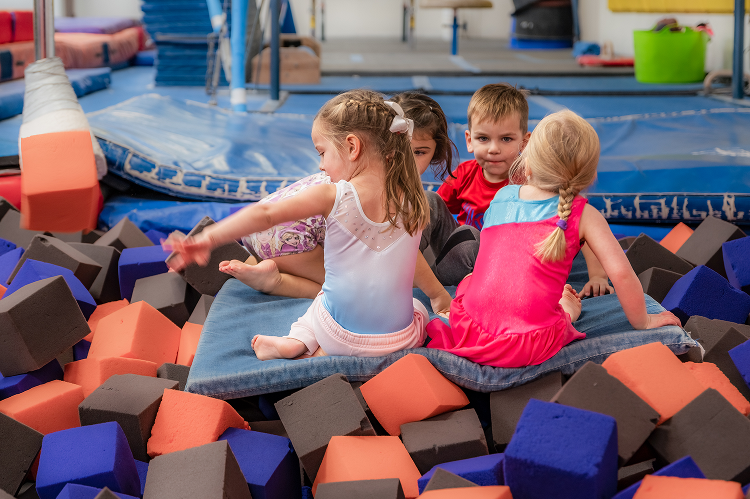 A group of children play happily in the foam block pit at Harpeth Gymnastics.