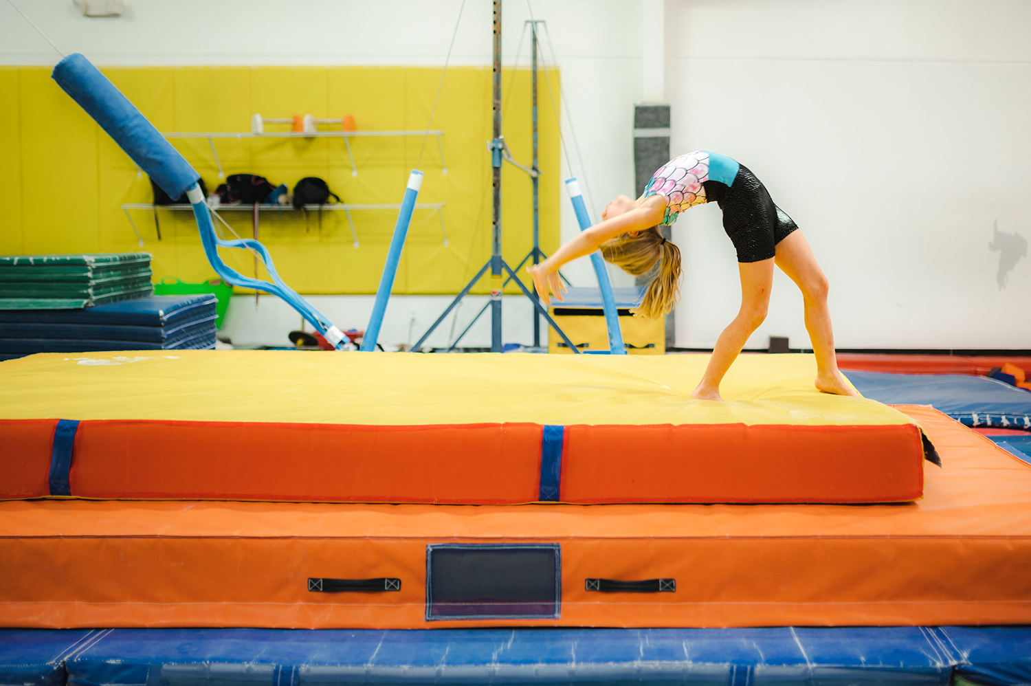 A girl begins the initial backbend portion of her back handspring on a practice mat at Harpeth Gymnastics.